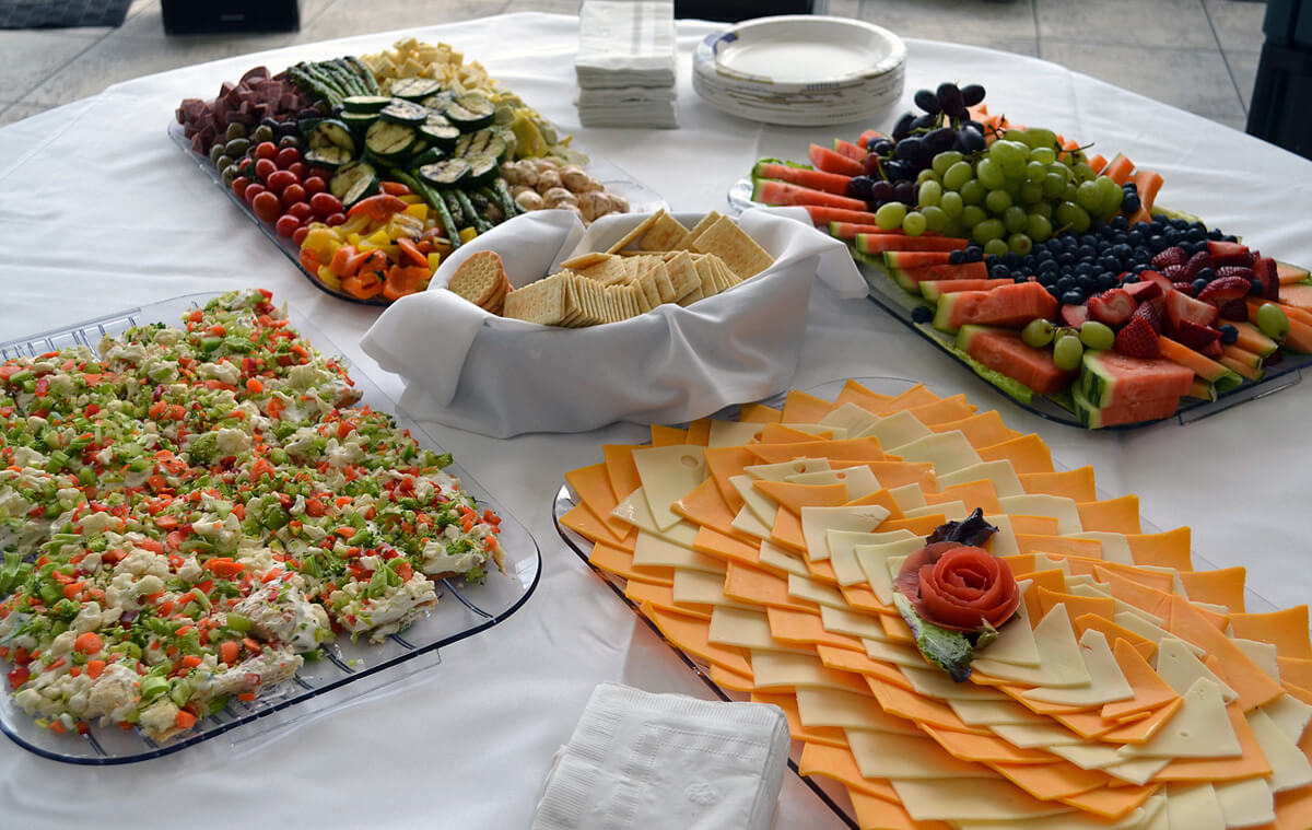 A Milwaukee Grill catering spread, including a cheese plate, fresh fruit, veggie platter, and more.
